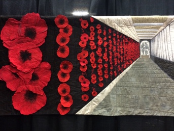 World Quilt Competition XVII: Honorable Mention - "Soldier On" by Lucy Carroll from Australia. Hand appliqued, machine appliqued, machine pieced, machine quilted, original design. Lucy writes: Soldier On is my interpretation of the Roll of Honour at the Australian War Memorial. The placing of poppy is a poignant act which connects us with fallen soldiers through the generations. When we visit the Memorial I take my children to place their own poppies beside the names of my friends and former classmates lost in recent conflicts.